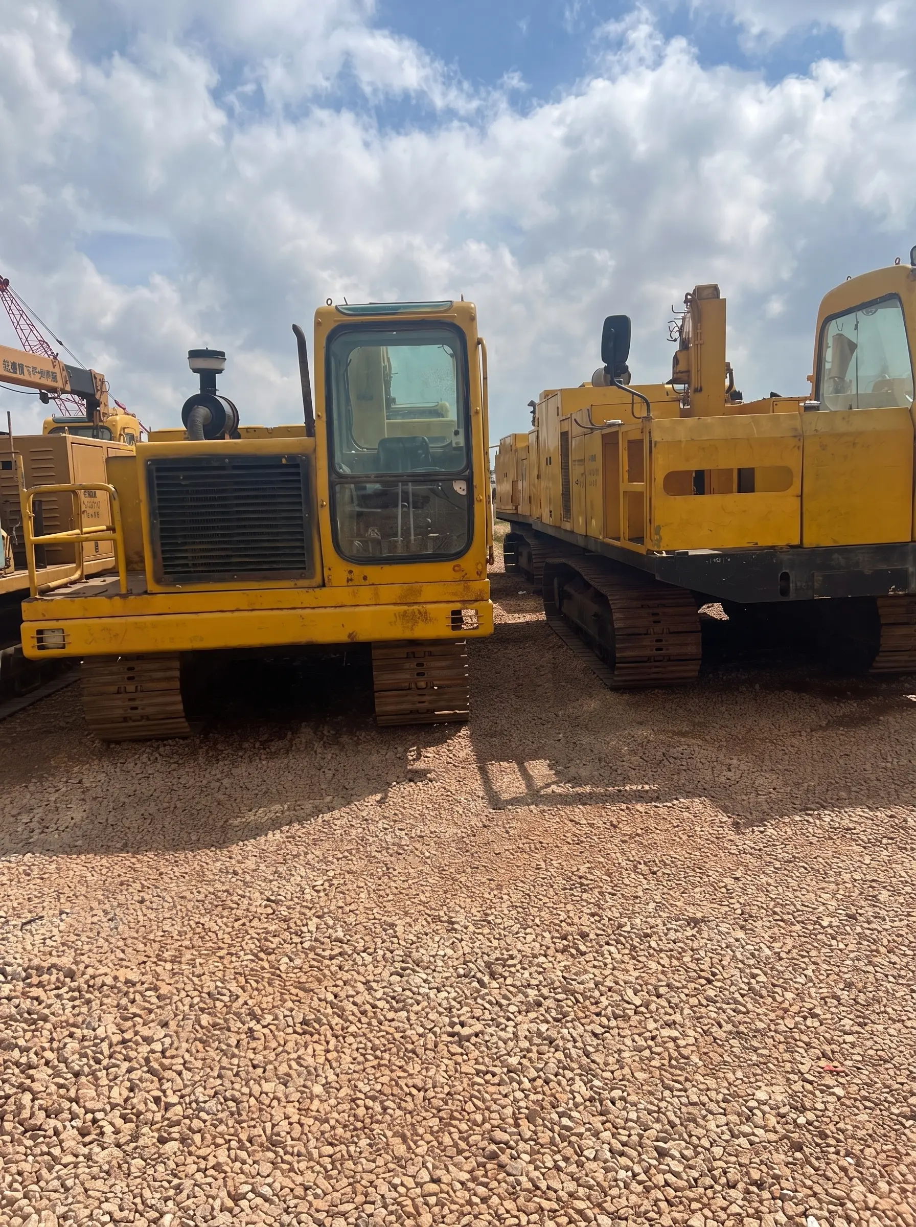 Yellow tracked construction equipment parked in a gravel storage yard.