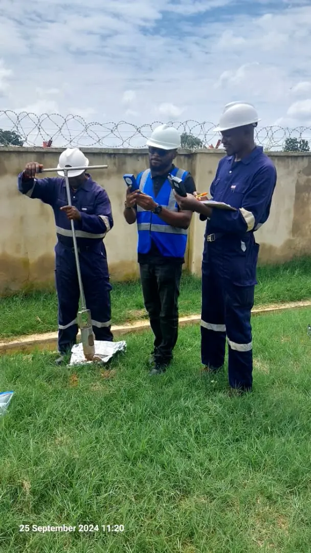 Environmental field team collecting soil samples and recording measurements during a site assessment.